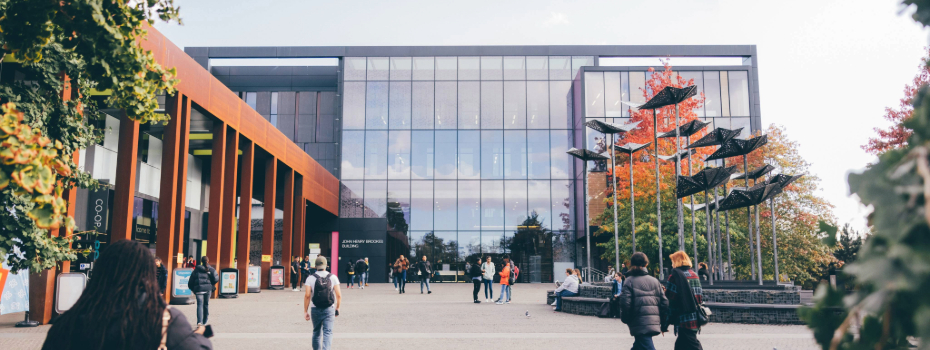 Students walking outside the John Henry Brookes Building on Headington Campus.