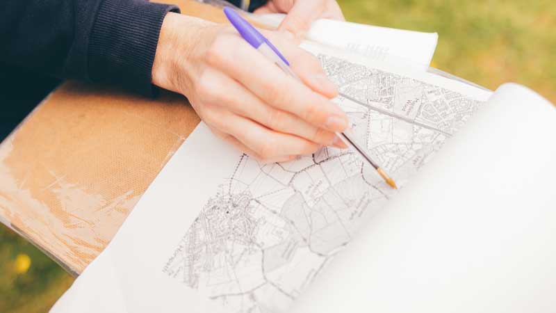 Student looking map of geographical features in landscape