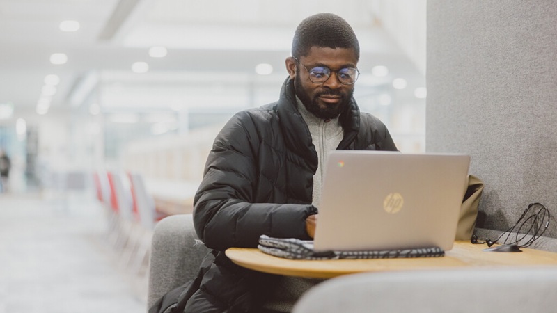 Student working on his laptop on campus