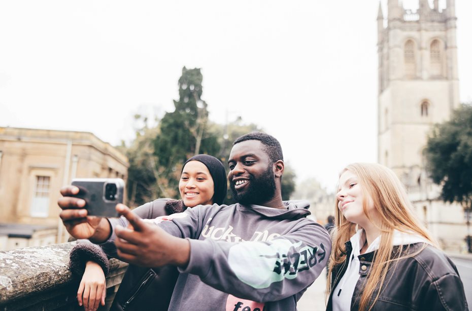 3 students taking a selfie on Magdalen bridge