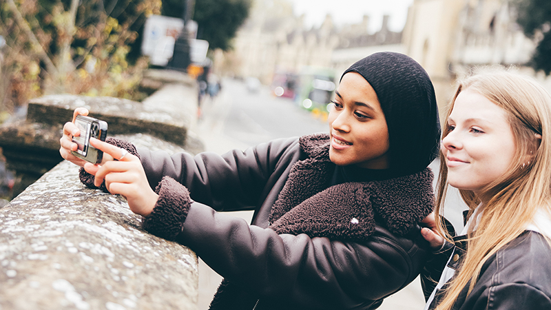 Two young women taking photos in Oxford