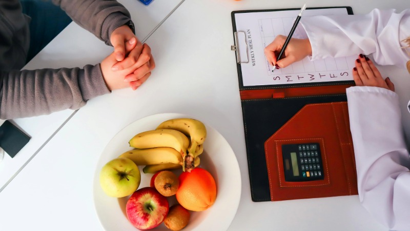 A dietetics appointment with fruit and a diary