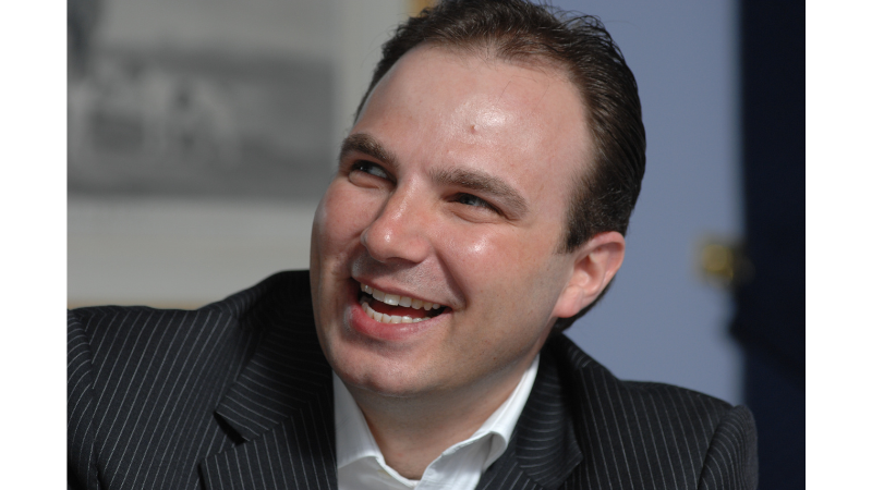 Nigel Stone smiling during a professional discussion or event.