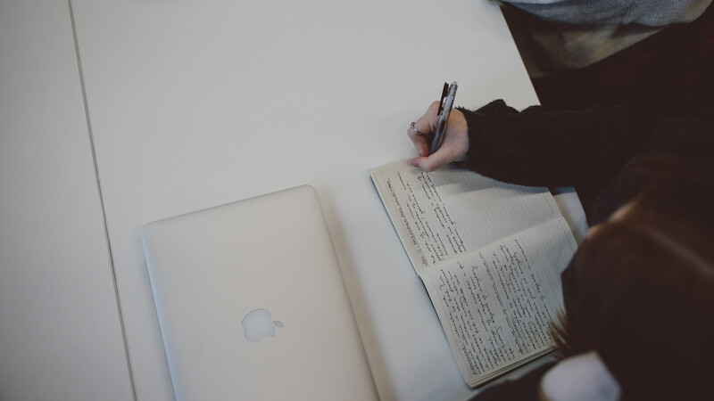 person writing in notebook