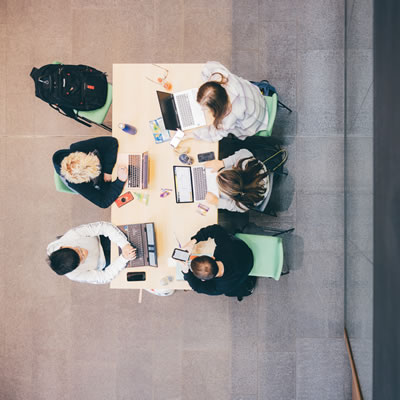 View of six students sitting at a desk from above