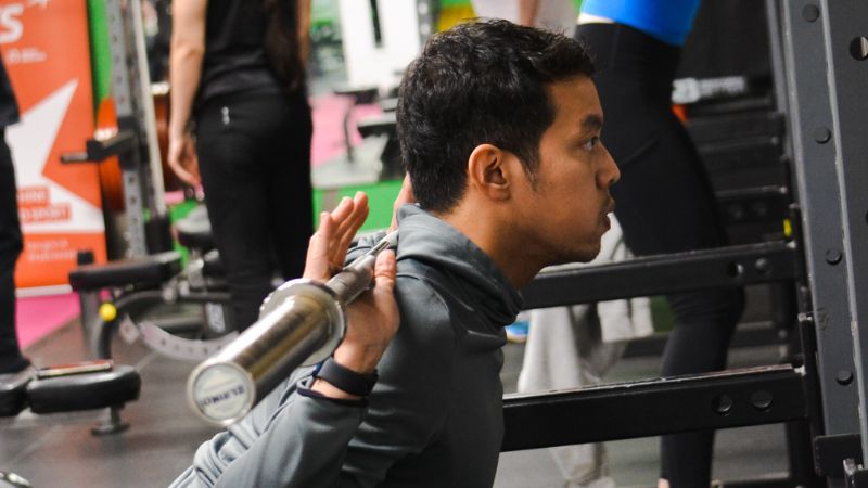 Athlete squatting in gym