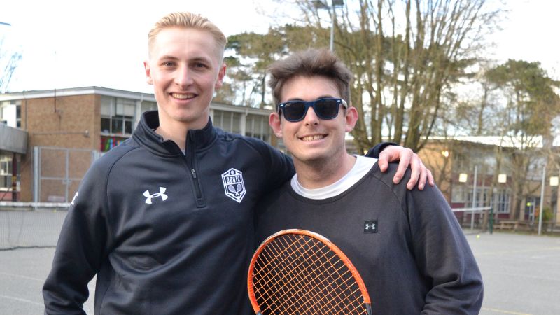 Two tennis players smiling at camera