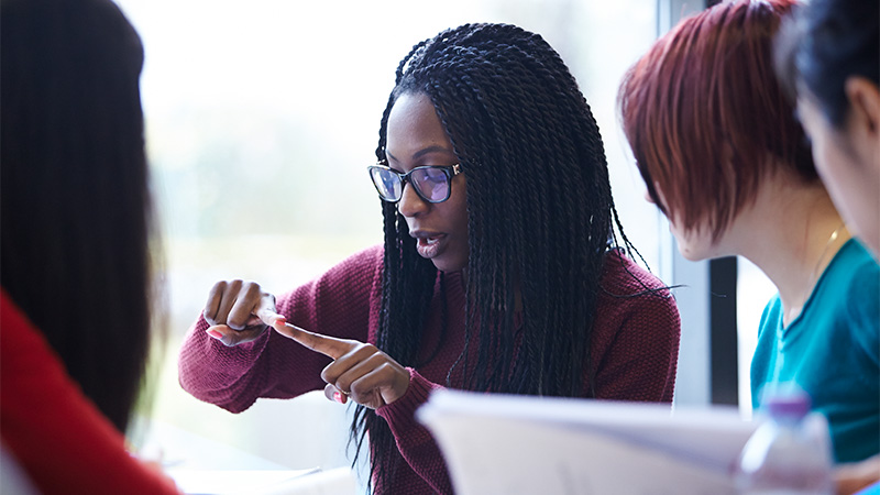 female student talking to fellow students