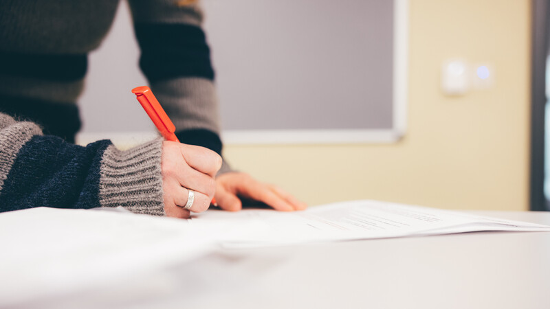 Close up of a person writing with a pen