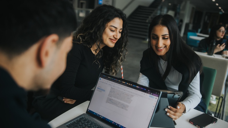 Business school students using a laptop for Digital Marketing