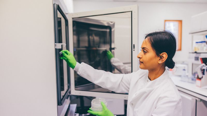 scientist in a lab coat using equipment