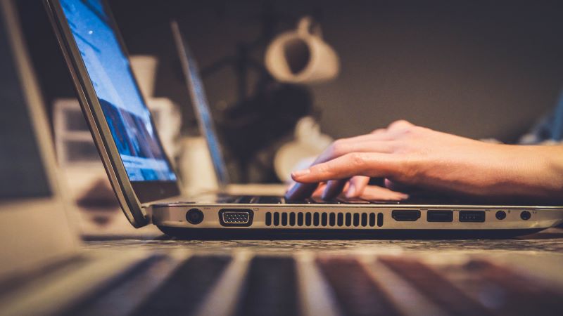 close up of hands typing on laptop
