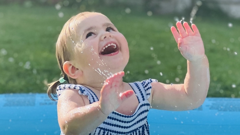 Little girl smiling in paddling pool