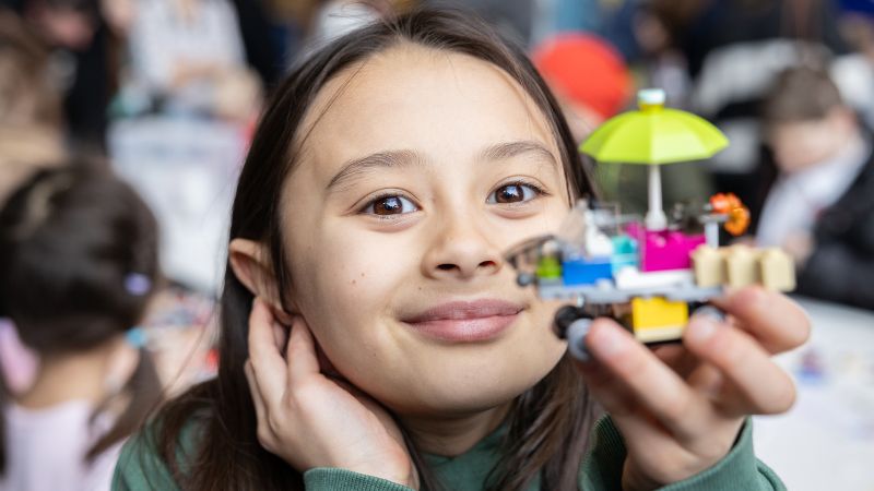 little girl with a lego piece in her hand
