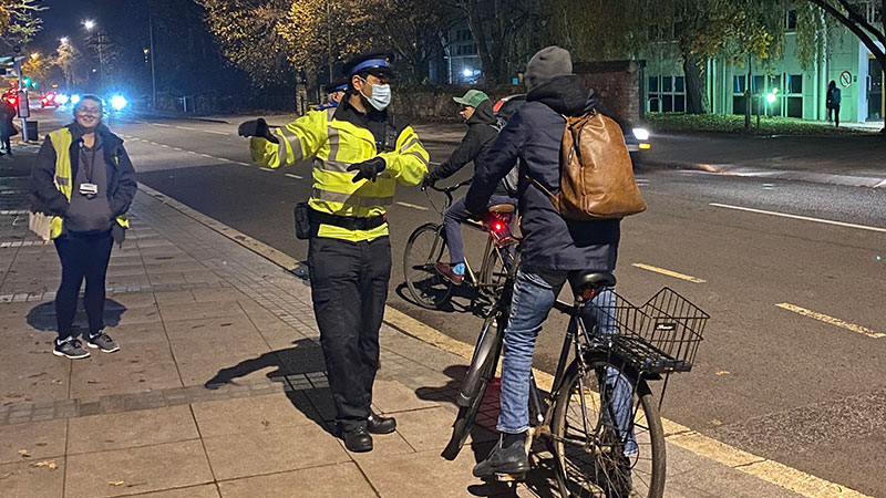 A police officer talking to a student on a bike