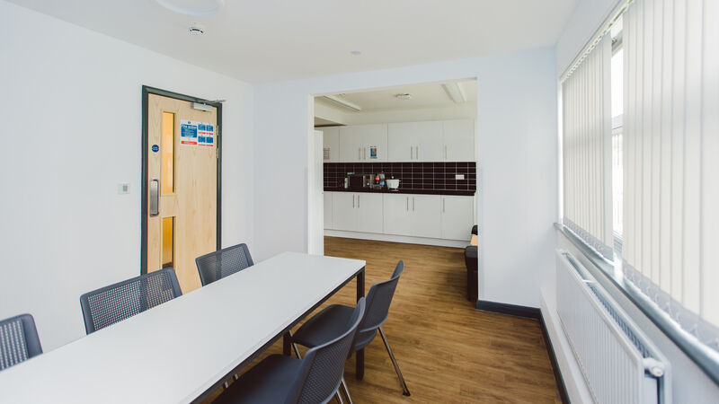 Large white dining table and chairs in room just off of the kitchen.