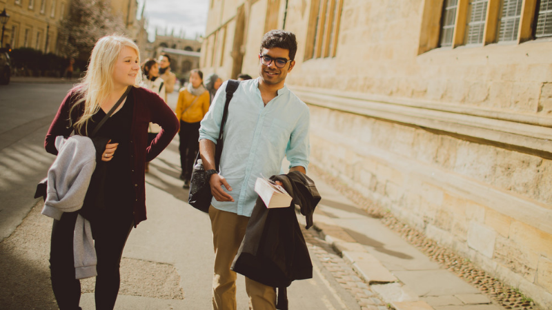 Two students talking and walking in Oxford