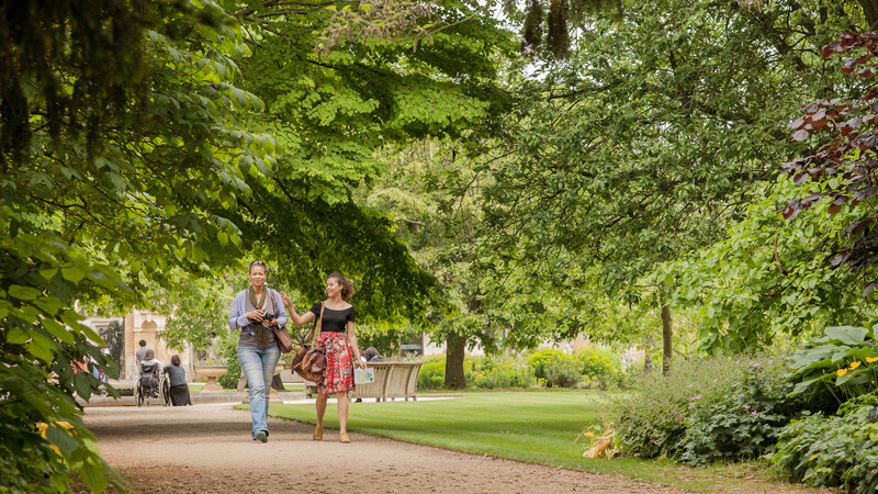 Two people walking through Oxford Botanical Garden