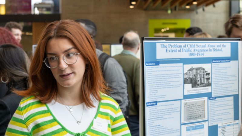 Isobel stood in front of their research poster