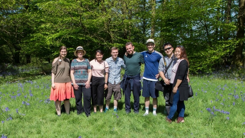 A group in front of a line of trees