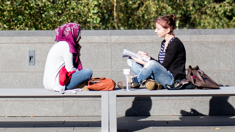 students chatting on a bench