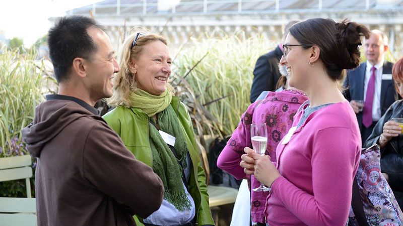 Three people talking at an alumni reuinion.