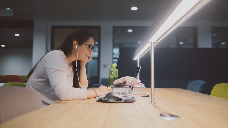 Student working at desk with light