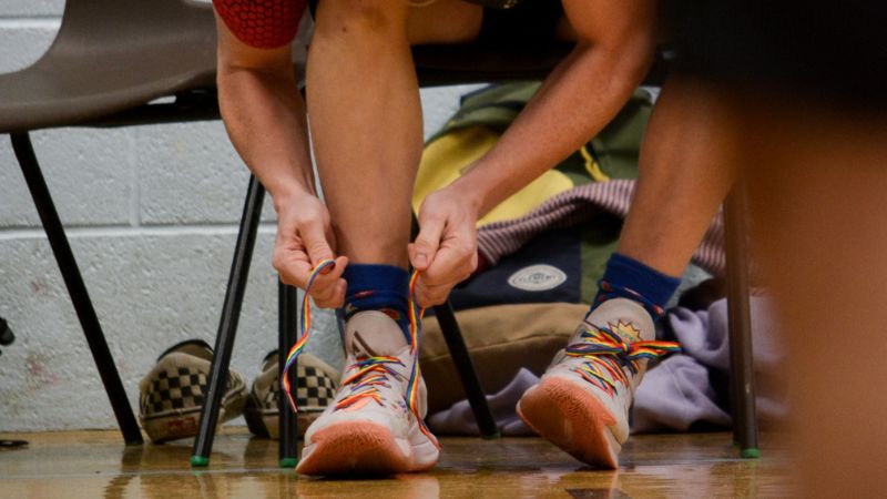 Student tying up rainbow laces 