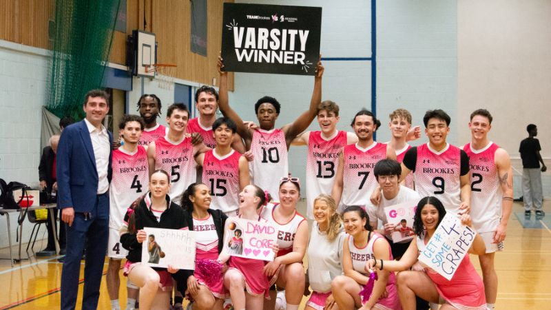Basketball teams celebrating Varsity win