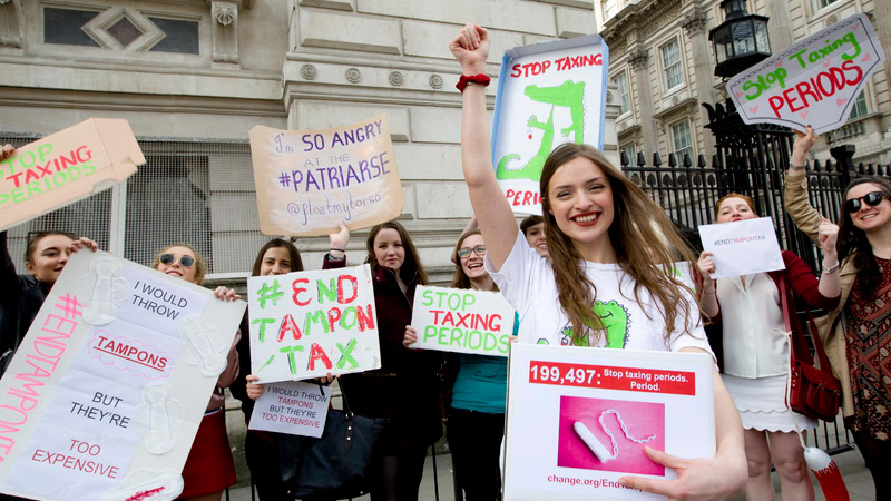 Image of people holding placards protesting the 'tampon tax'