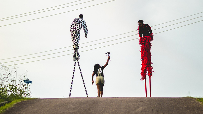 View of two people on stilts from behind