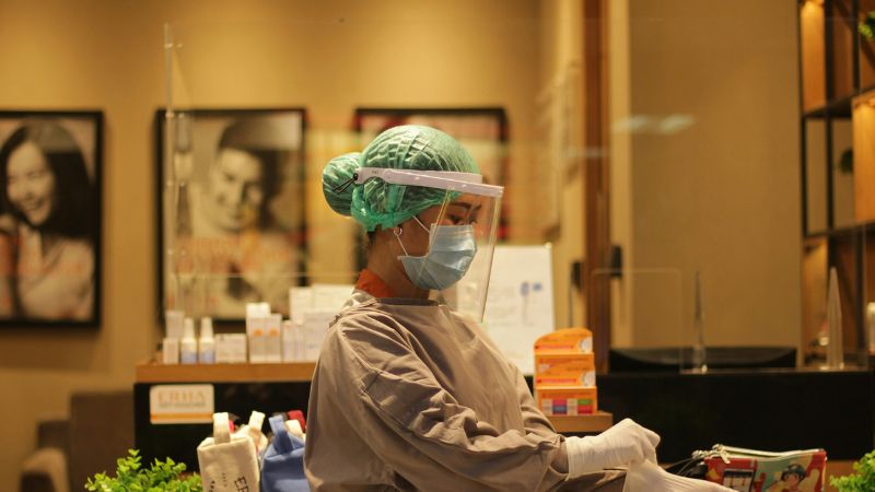A worker wearing a mask and face shield
