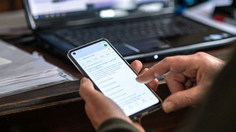 person scrolling through a screen on their smart phone