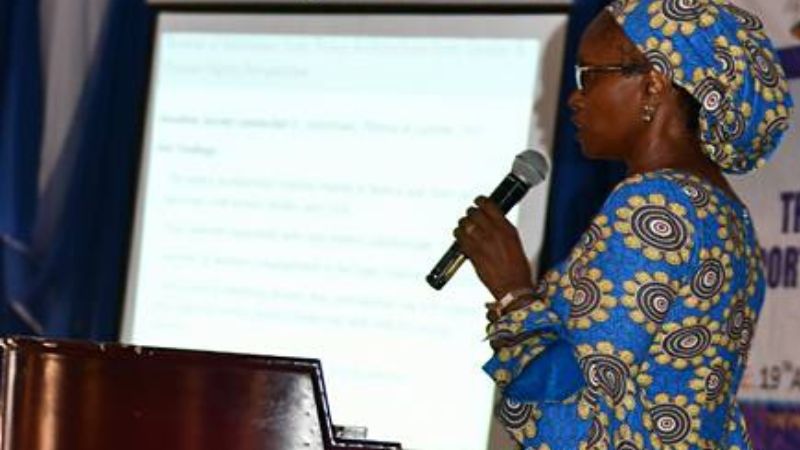 Njeri Karuru speaking at an event with a microphone in her hand