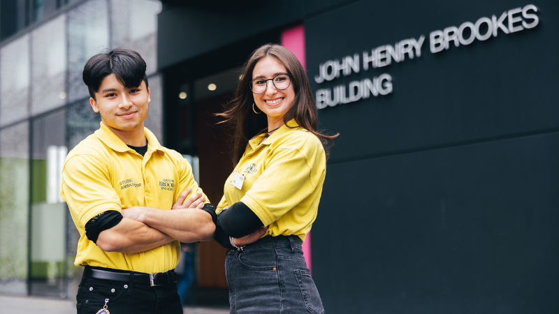 Two Student Ambassadors standing outside the John Henry Brookes Building.