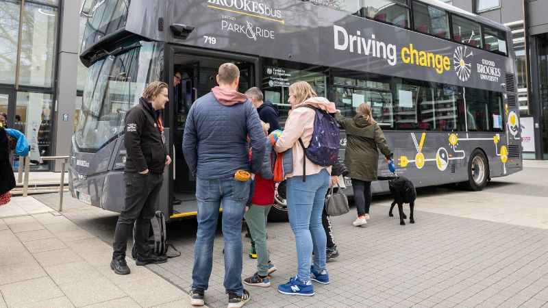 people in front of an oxford brookes bus at headington campus